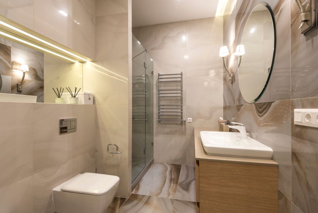 Commercial washroom with glass shower enclosure and wall-hung fixtures