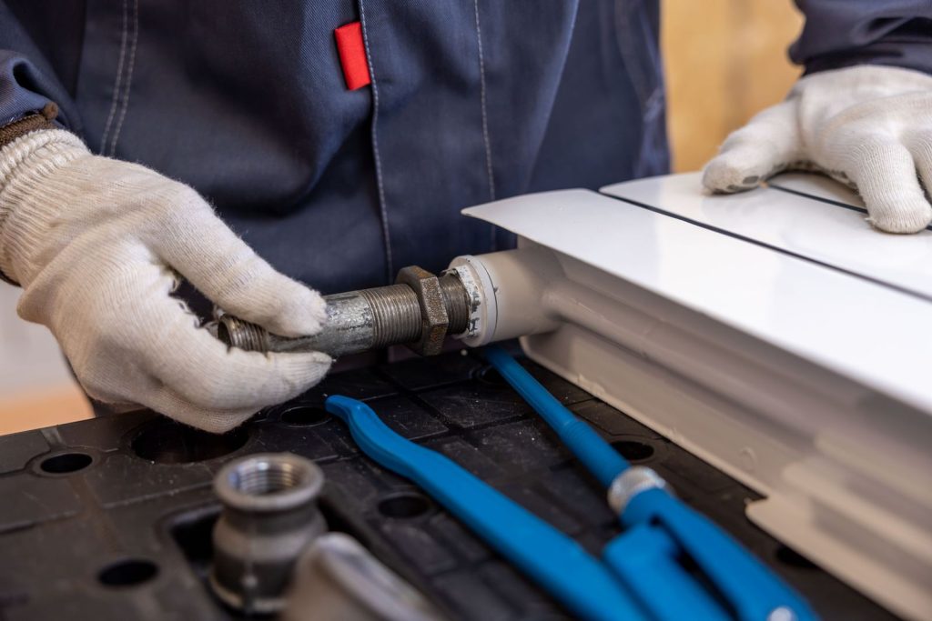 Plumber fitting a heating pipe connection with specialist tools