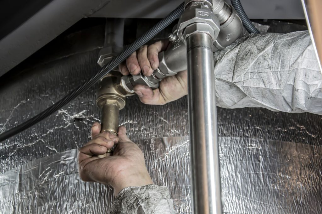 Plumber hands installing steel pipe fittings