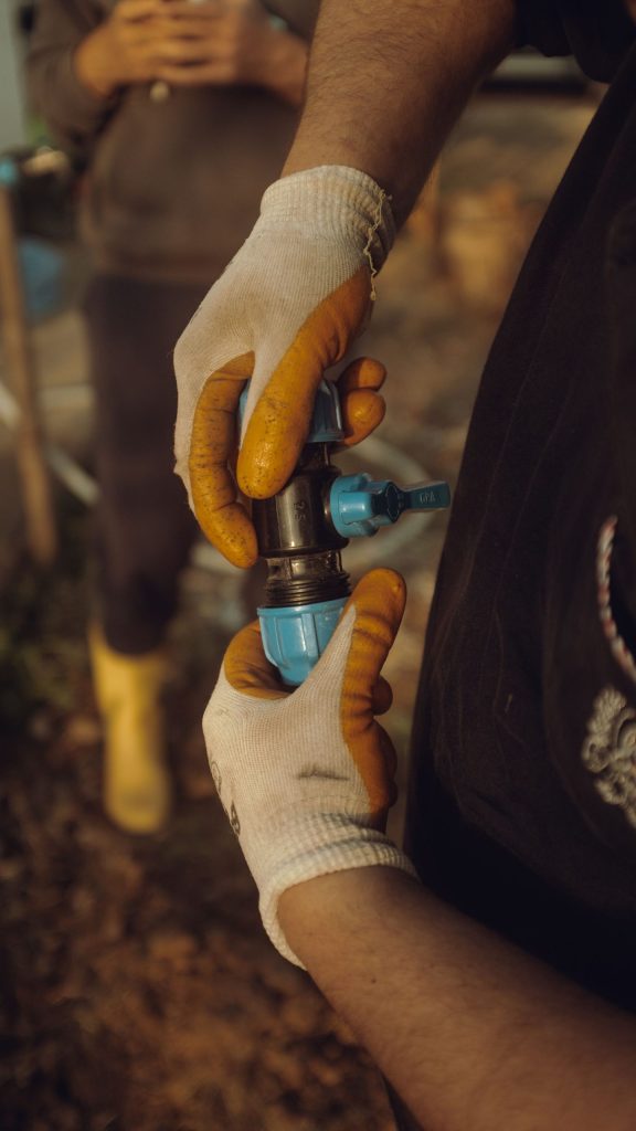 Construction worker joining pipe sections by hand